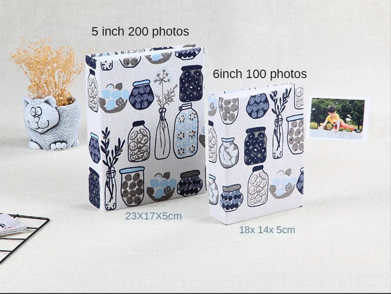 Two photo albums, one 5 inch with 200 photos and one 6 inch with 100 photos, displayed on a white surface.