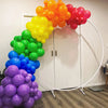 A vibrant balloon garland arch featuring rainbow colors like orange, yellow, green, blue, and pink clustered together.