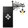 Black wrought iron decorative lantern light fixture with a spiderweb design mounted on a rectangular bookshelf.