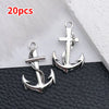 A pair of silver vintage ship anchor charms with braided ropes displayed on a dark surface.