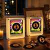 A pair of magnetic vinyl record night lights glowing with an LED light, resting on a wooden surface.