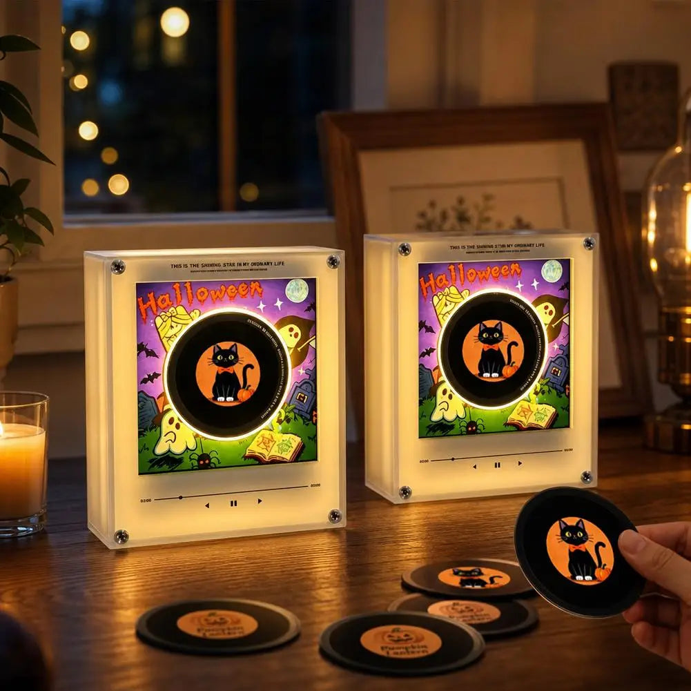 A pair of magnetic vinyl record night lights glowing with an LED light, resting on a wooden surface.