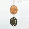 Two layers of macrame hat organizers featuring a light brown and olive green felt hat hanging from a wooden dowel