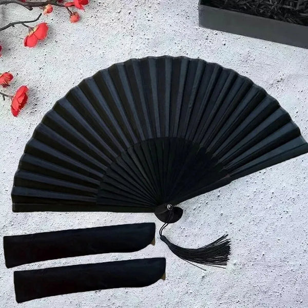 A black folding hand fan with a bamboo frame is displayed on a white surface.