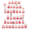 A collection of vintage pink and rose-colored glass vases and bottles arranged in a vertical display.