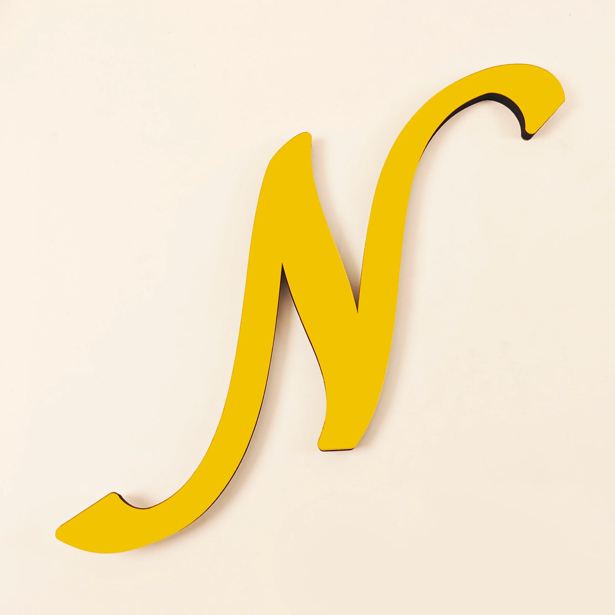 A yellow 3D acrylic letter N wall sticker against a light background.