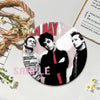 A set of collectible button pins featuring portraits of punk band members on an album cover design.