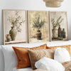 A gallery wall featuring three framed canvas prints of olive branches and greenery in earthy tones.
