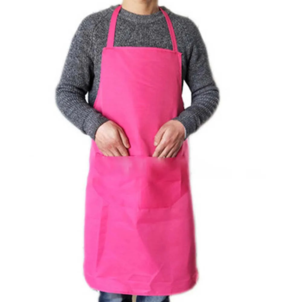 A person wearing a bright pink waterproof kitchen apron with a front pocket over a gray sweater.