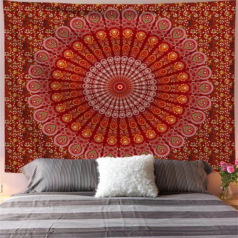 Red and orange bohemian mandala tapestry wall art hanging above a bed.