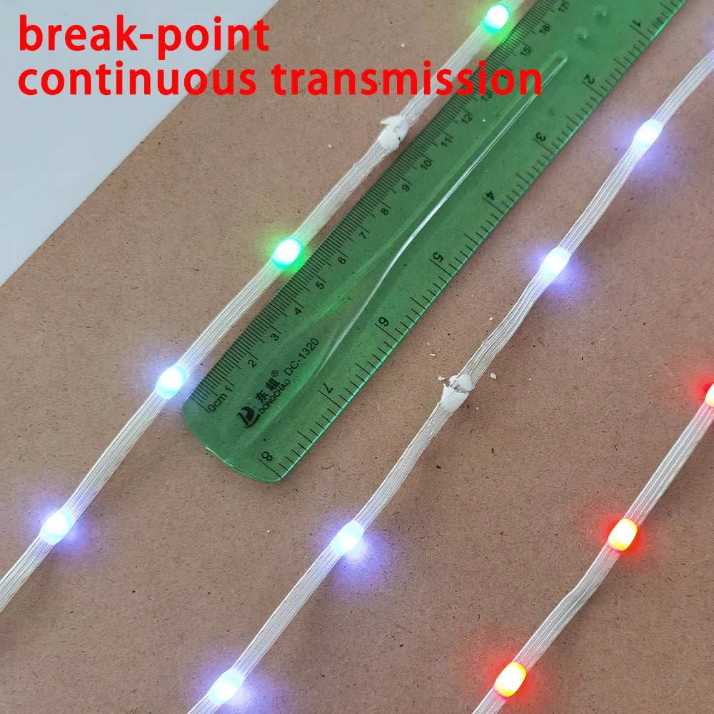A close-up of a green ruler showing continuous transmission of addressable LED string lights.