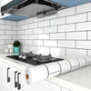 A roll of white waterproof oil-proof kitchen wall sticker placed on a white countertop in a modern kitchen setting.