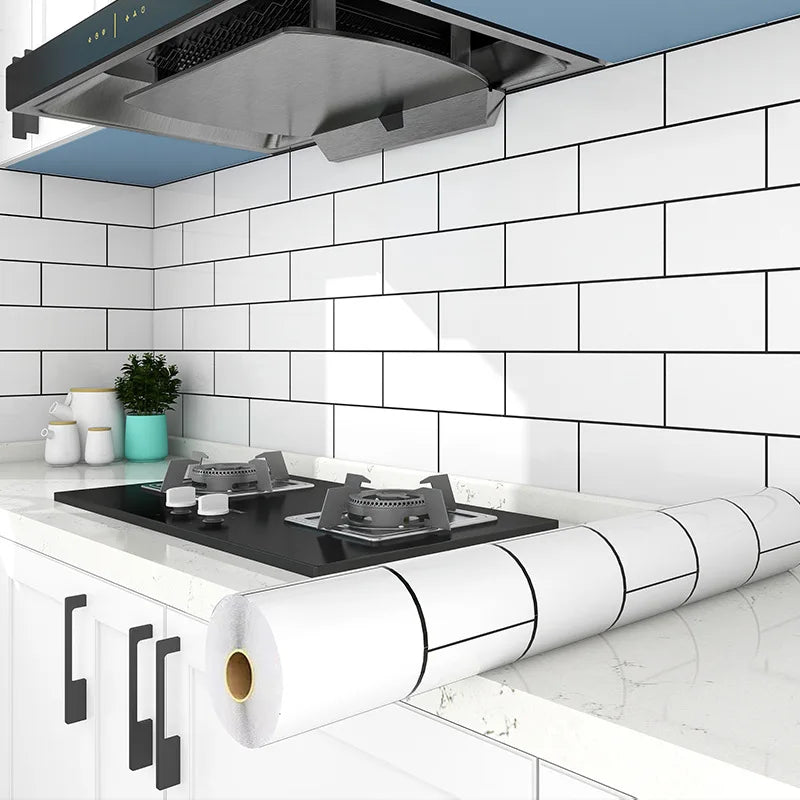 A roll of white waterproof oil-proof kitchen wall sticker placed on a white countertop in a modern kitchen setting.
