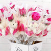 A bouquet of artificial pink and white roses made of soap wrapped in clear plastic.