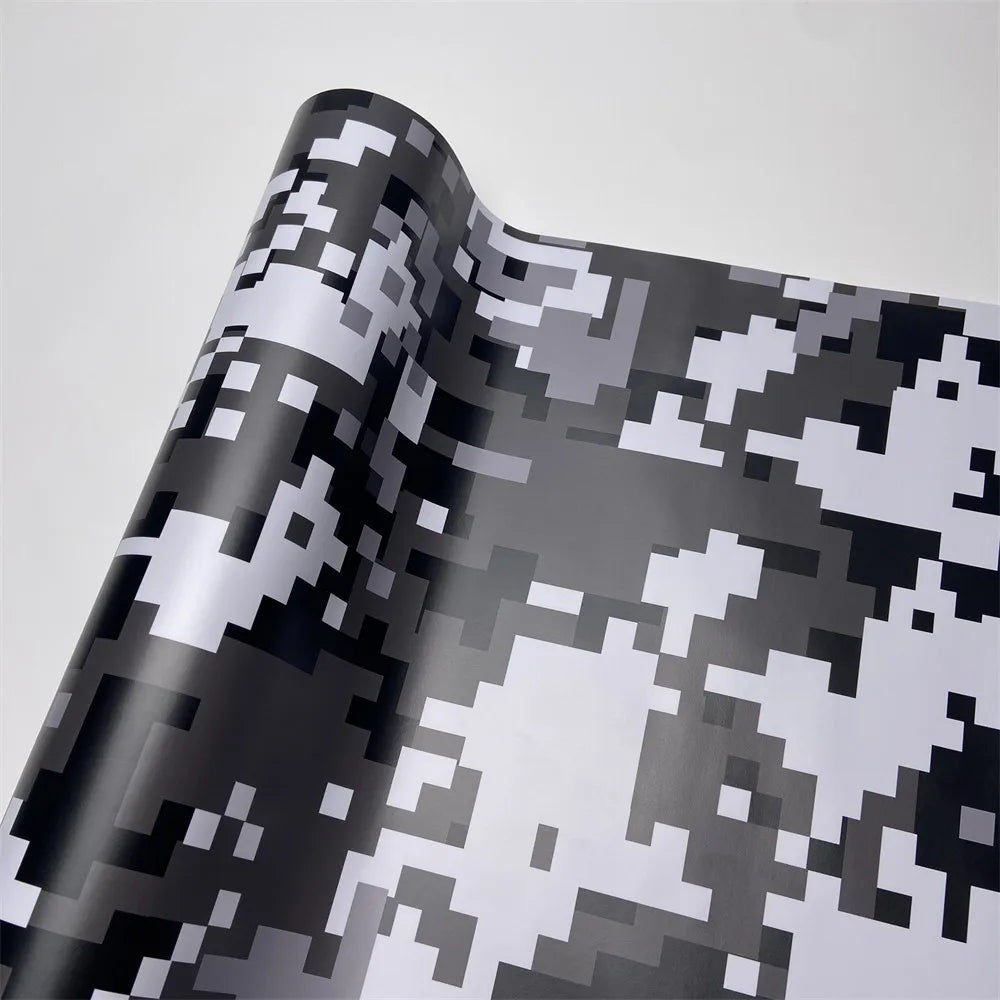 Roll of color-changing digital camouflage vinyl wrap film showing a gray and white pattern.