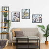 A modern living room display featuring framed artwork and a light gray sofa.