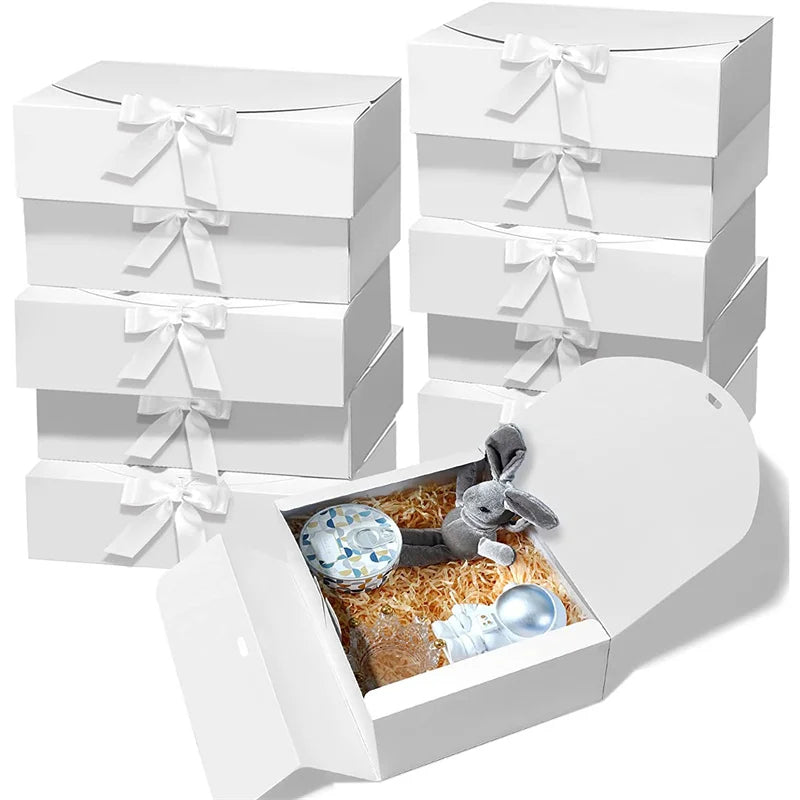 A stack of white kraft paper gift boxes tied with white ribbons, with one box open showing a rabbit figurine.