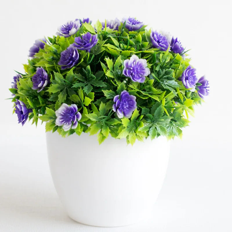 Un vibrant arbre bonsai artificiel vert avec des fleurs violettes dans un pot blanc.