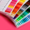 A collection of dual-ended watercolor art markers in various bright and deep colors arranged in a white plastic case.