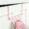 Pink heart over-the-door hook rack with five hooks mounted on a white cabinet door.