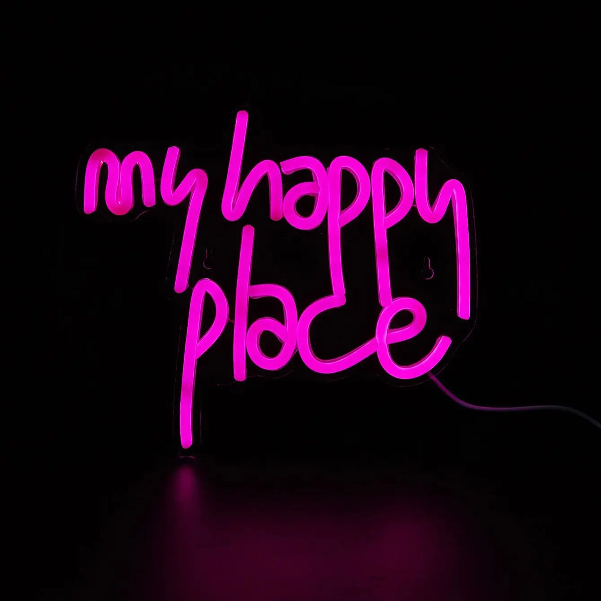 A neon sign spelling out My Happy Place in bright pink light against a dark background.