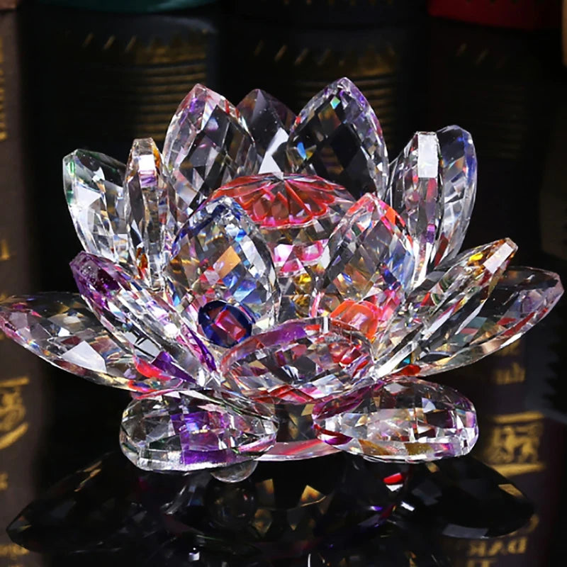 A clear crystal lotus flower ornament with pink and purple facets resting on a dark surface.
