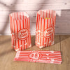 Two red and white striped paper popcorn buckets filled with popcorn