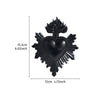 A black resin flame heart wall decoration with radiating spikes.