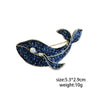 A vintage marine life brooch pin featuring a dark blue fish design adorned with sparkling blue stones.