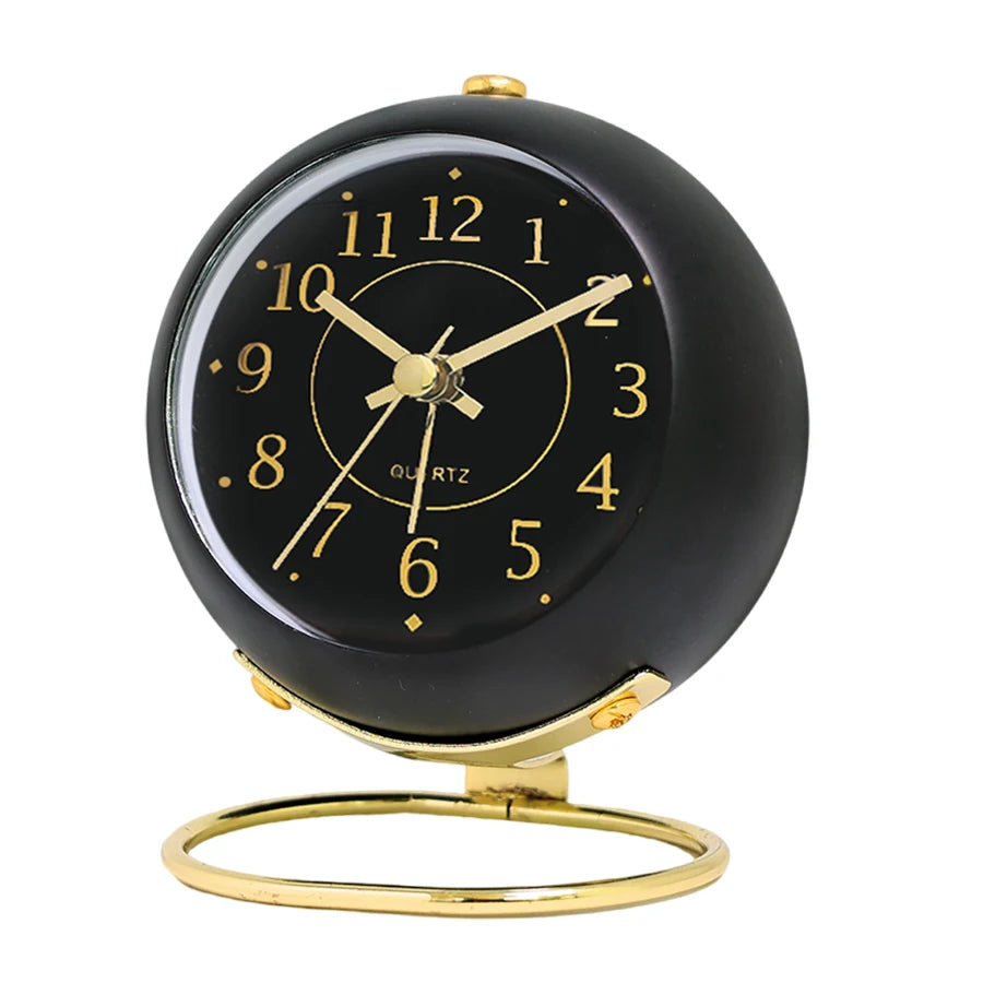 A black minimalist Nordic alarm clock with gold accents and a soft night glow.