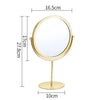 A round, gold-toned metal makeup mirror with a stand, measuring 16.5cm in diameter and 27.8cm in height.