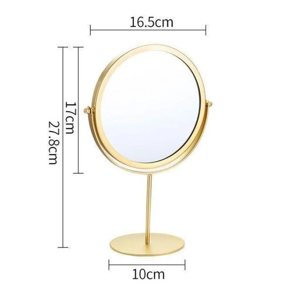 A round, gold-toned metal makeup mirror with a stand, measuring 16.5cm in diameter and 27.8cm in height.