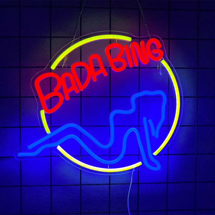 Neon wall sign featuring the text BADA BING and a blue lightning bolt design on a dark background.