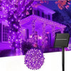 Purple LED string lights illuminating a house and tree for outdoor decoration