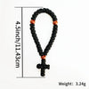 A black 33-knot Orthodox prayer rope with a small wooden cross charm displayed against a white background.