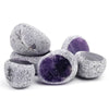 A collection of tumbled natural crystals including clear quartz, rose quartz, and amethyst stones.