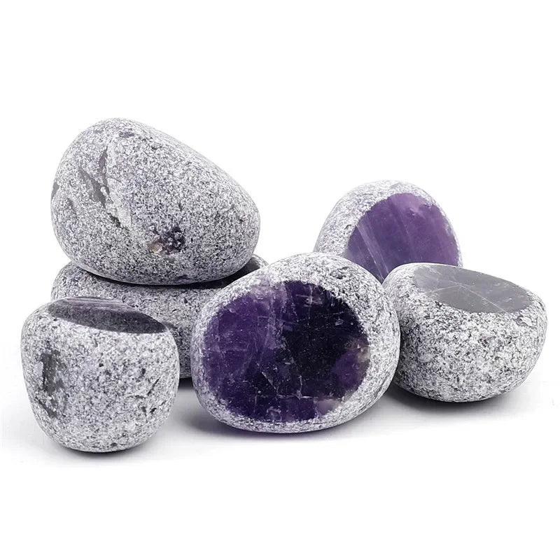 A collection of tumbled natural crystals including clear quartz, rose quartz, and amethyst stones.