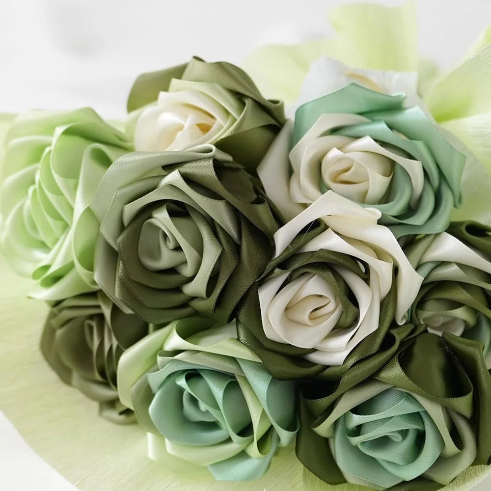 A bouquet of satin silk ribbon roses in shades of sage green, cream, and pale mint green.