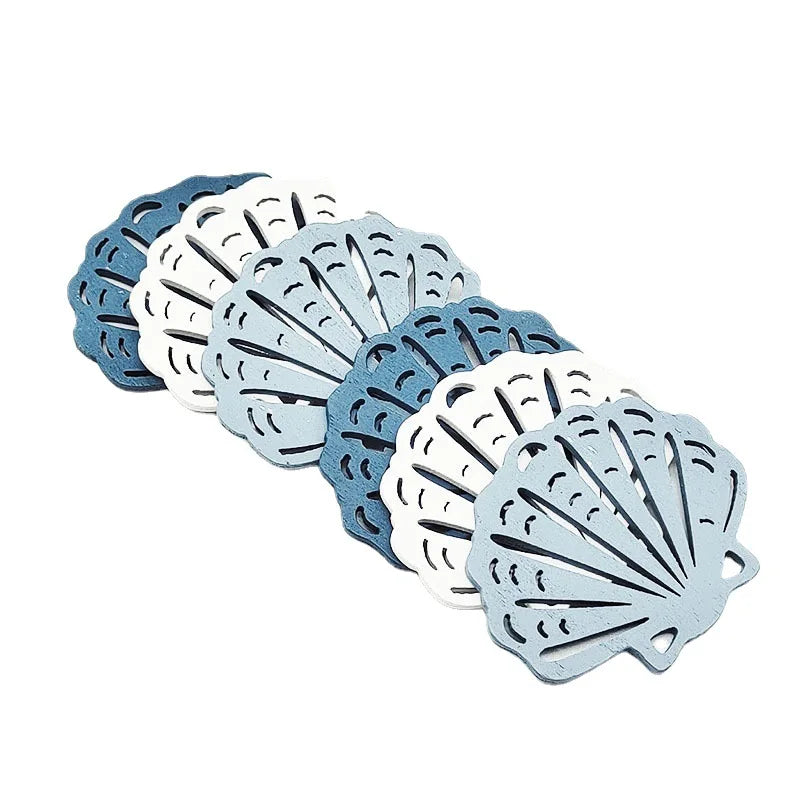 A set of twelve wooden ocean ornaments shaped like shells, scallops, and starfish in shades of blue and white.