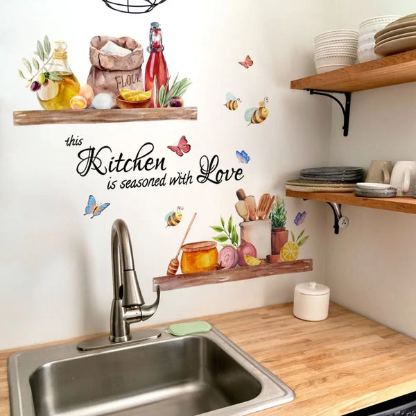 A kitchen wall decorated with bee and butterfly decals above a stainless steel sink.