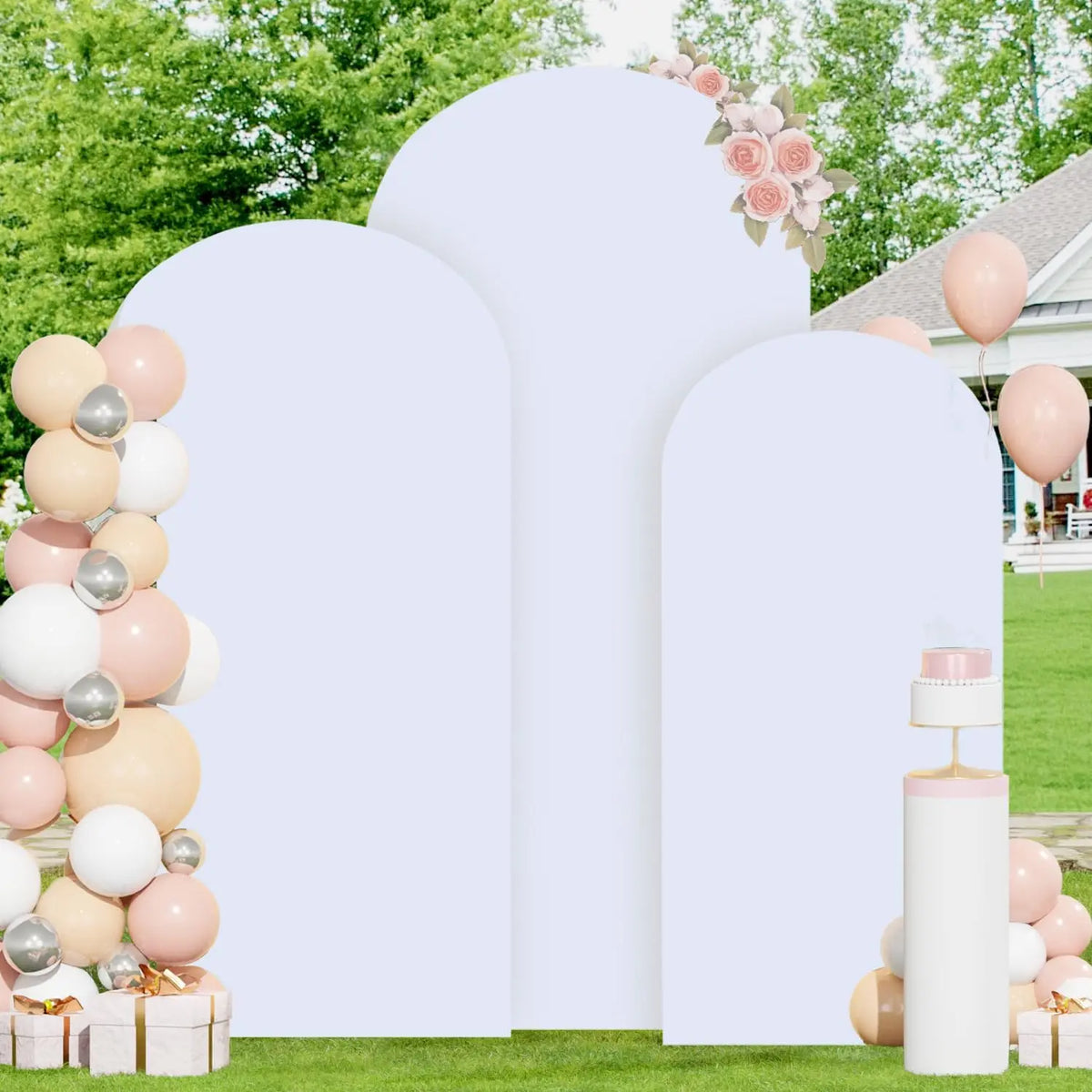 A white double-sided arch backdrop cover decorated with pink roses and spherical balloons in various shades of peach, cream, 