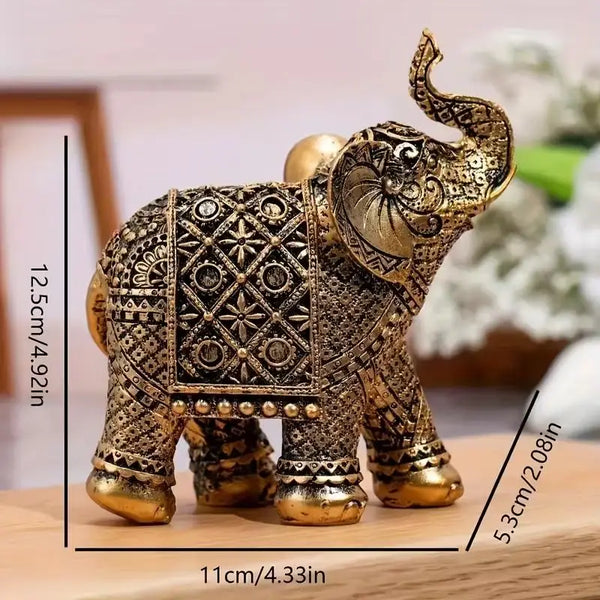 A vintage resin elephant ornament with gold detailing, displayed on a wooden surface.