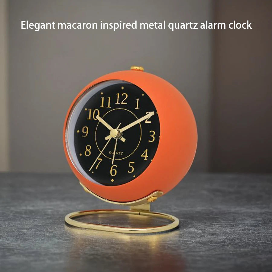 An elegant macaron-inspired metal quartz alarm clock with an orange face and black dial.