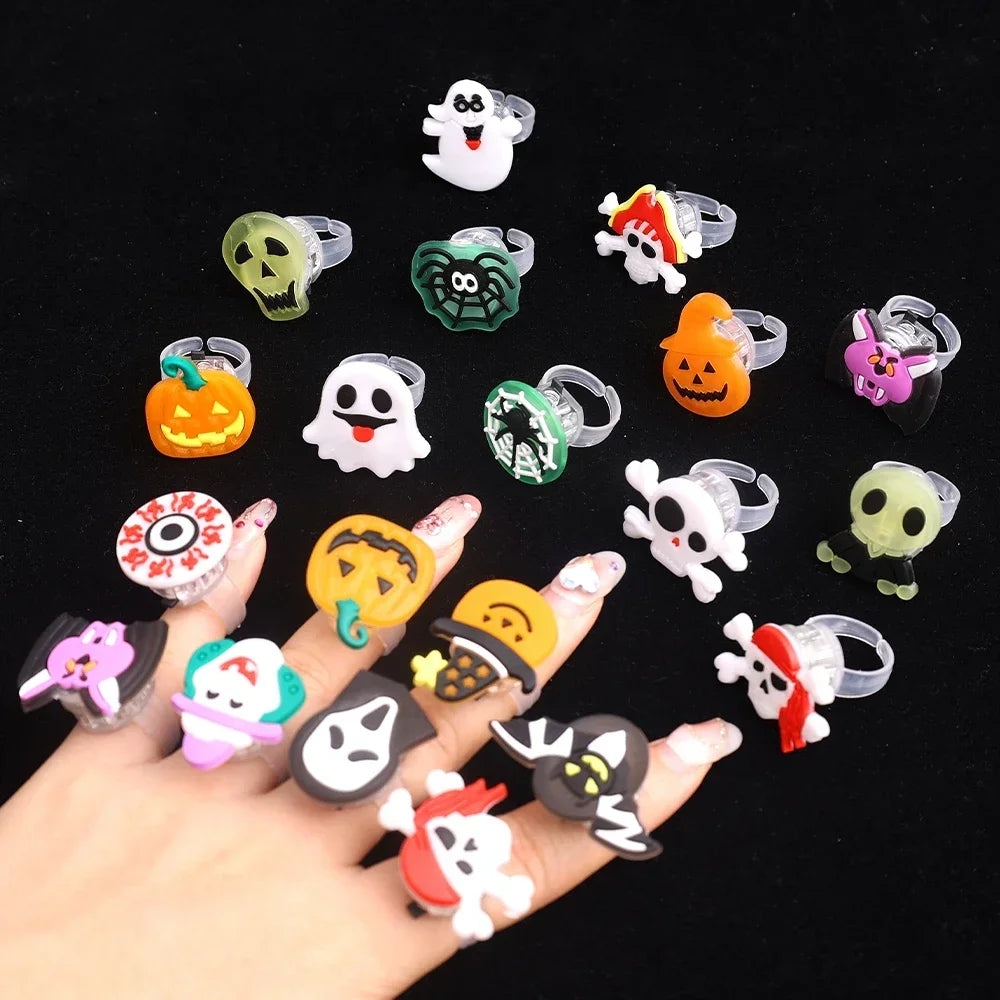 A collection of glow-in-the-dark Halloween rings featuring skulls, pumpkins, and spooky faces.