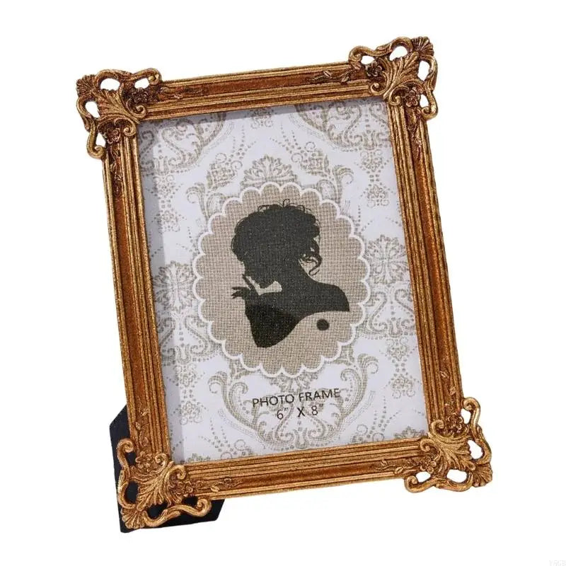 A gold-framed photo frame with a vintage European design featuring a white background and an engraved silhouette.