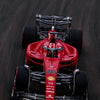 A red Formula 1 racing car model on a dark background.