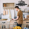 A rustic farmhouse metal wall sign for kitchen and dining room hangs above wooden cabinetry.