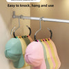 A silver hanger displaying multiple colored hats and headwear on a closet rod.