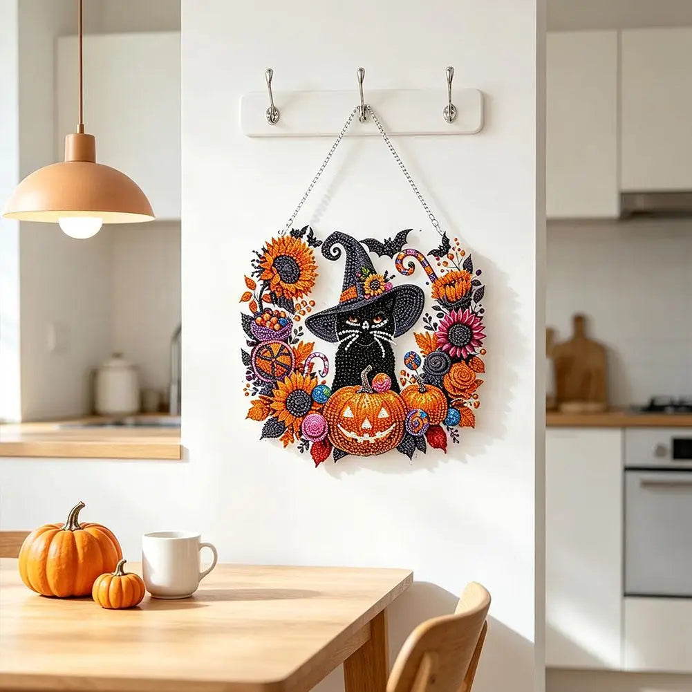 Acrylic diamond painting kit featuring black cat, moon, skull, and pumpkin designs displayed on a white wall.