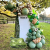 Décoration de fête Mission 10 avec un grand panneau blanc décoré d'une couronne de ballons en feuille de bronze et vert.